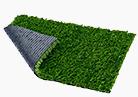 Corner of artificial grass dog potty pad rolled up showing the mesh backing.